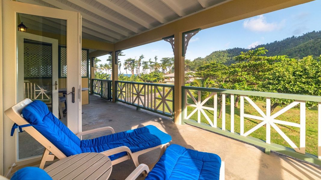 Garden View Premier veranda with chairs and views across tropical gardens to the mountains