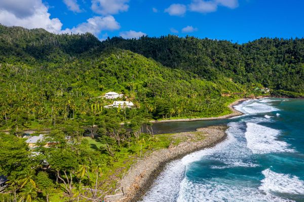 The Rosalie River’s mouth beside the black-sand shoreline and forested hills
